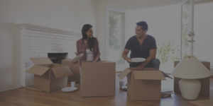 Couple Unpacking Boxes In New Home On Moving Day